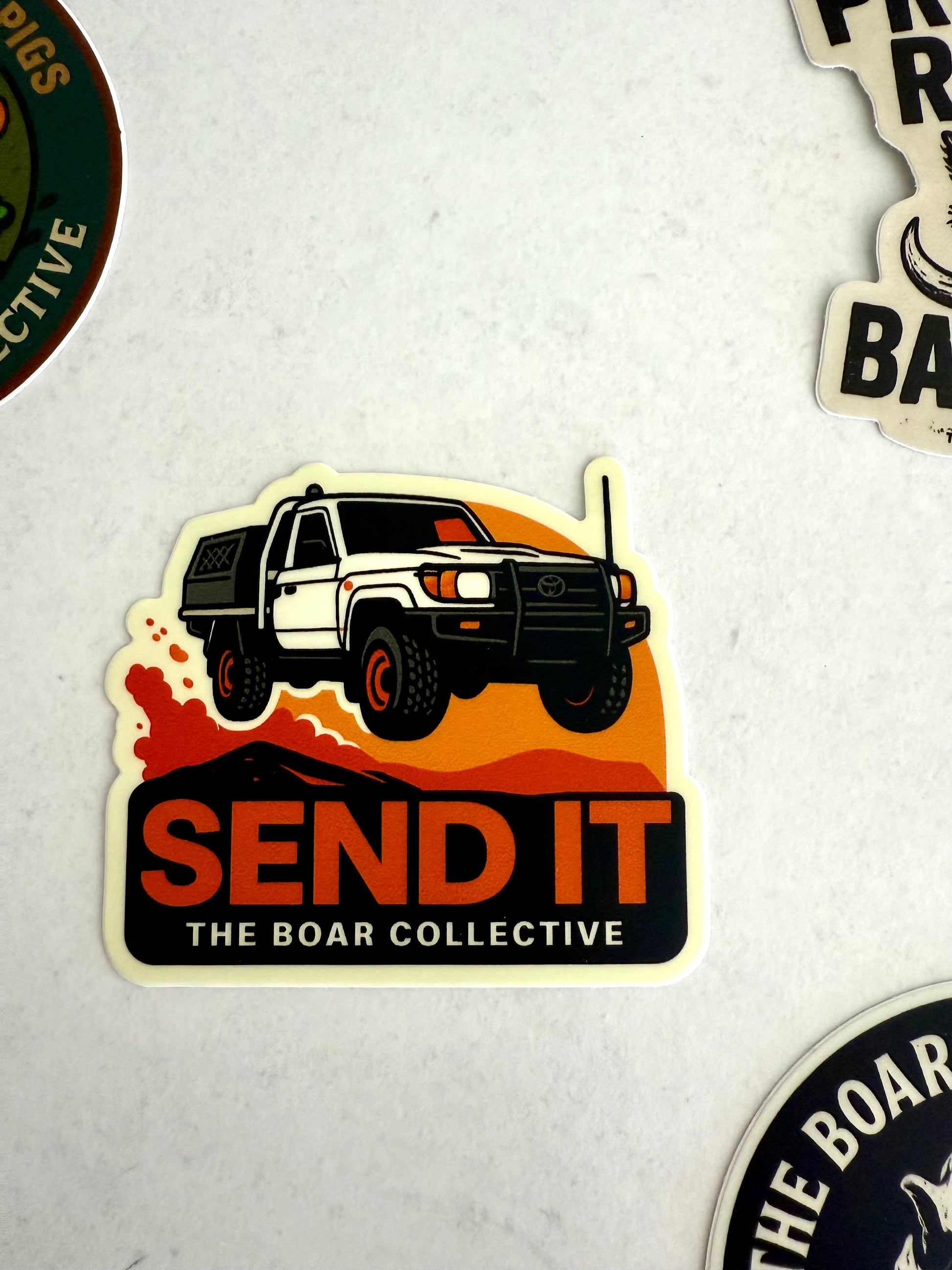 Send It sticker featuring a 4WD LandCruiser jumping over hills at sunset by The Boar Collective